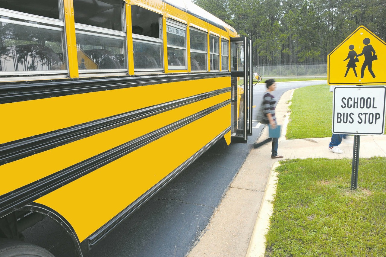 Student exiting school bus at bus stop